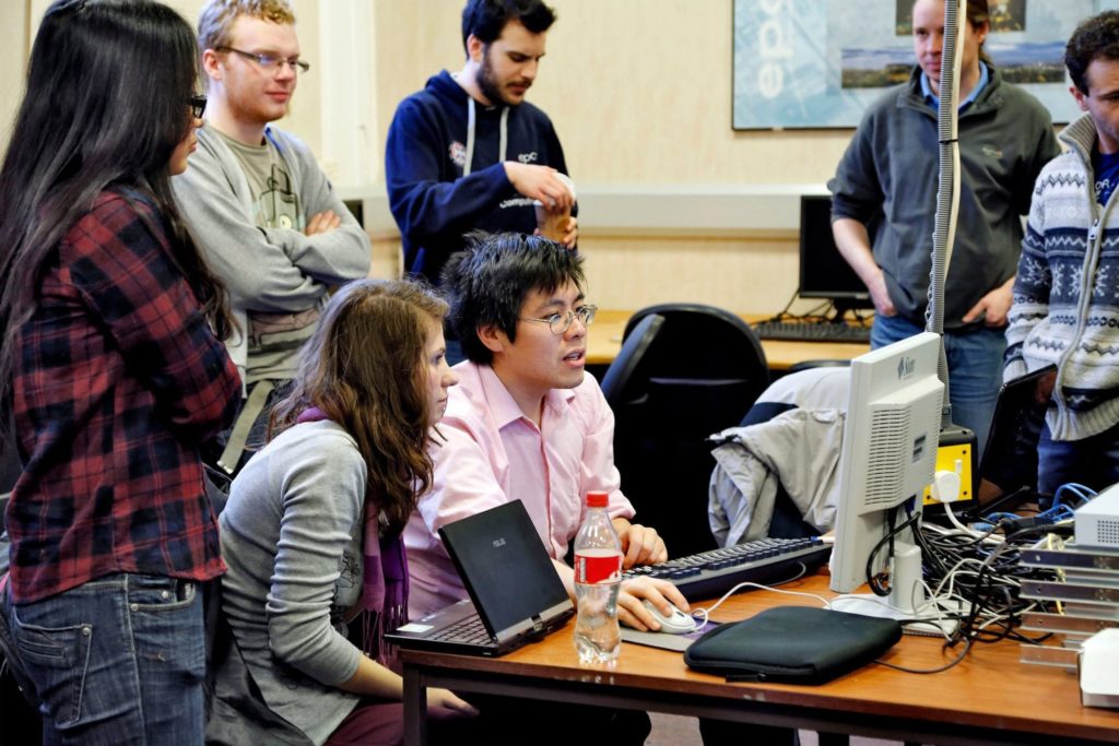 Researchers collaborating around a computer
