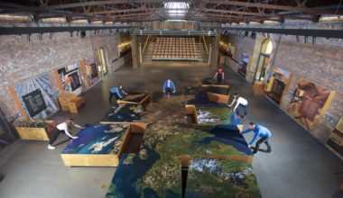 People putting together huge blocks with image of scotland on them