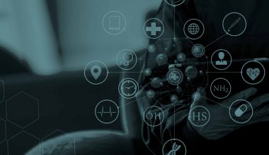 Medical icons overlay a tinted picture of a doctor or nurse in PPE using an iPad