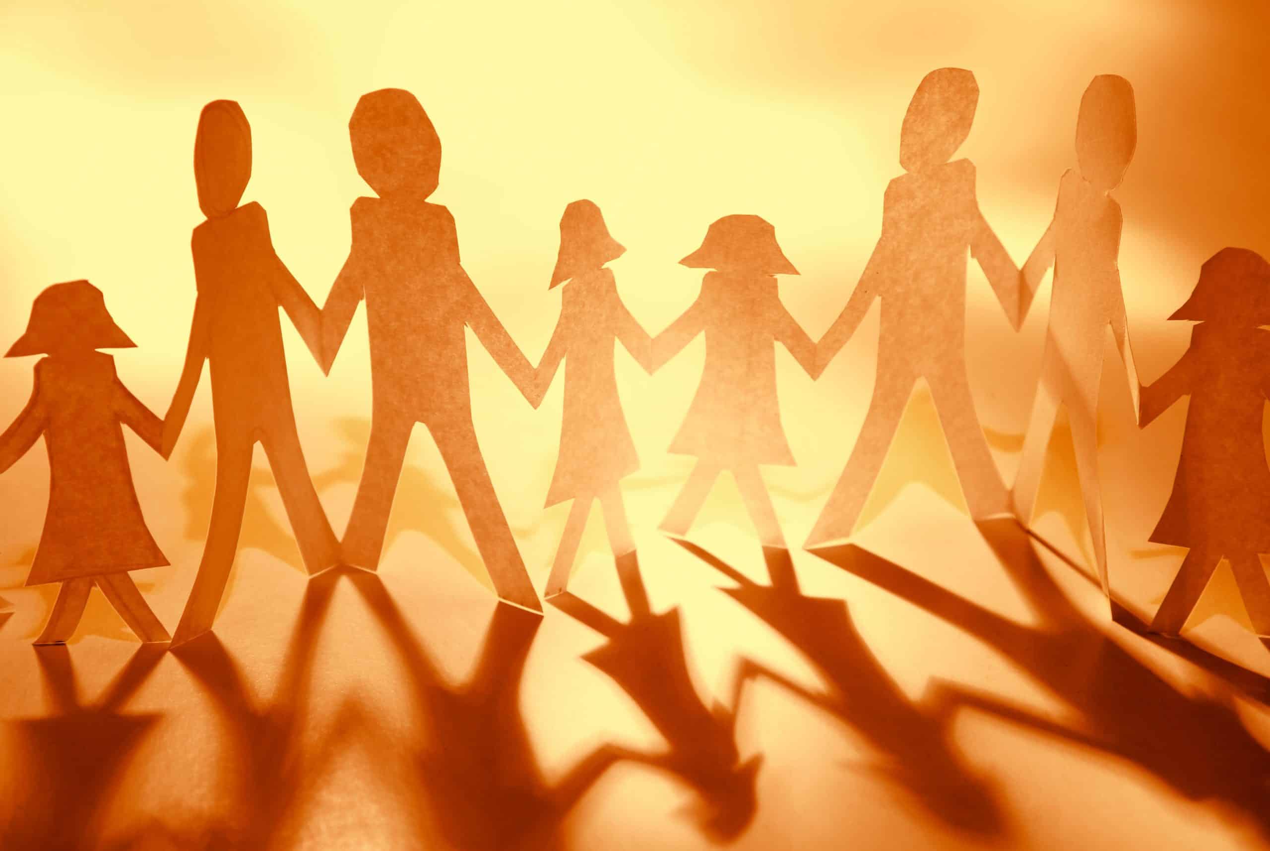 Photo of paper cut out of family figures with linking hands